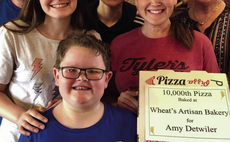 Amy Detwiler, along with family, recently purchases the 10,000th pizza made a Wheat’s Artisan Bakery. Wheat’s Artisan Bakery, 424 Commerce St., is open 11 a.m.-7 p.m. Wednesday-Saturday. Photo Courtesy of Wheat’s Bakery