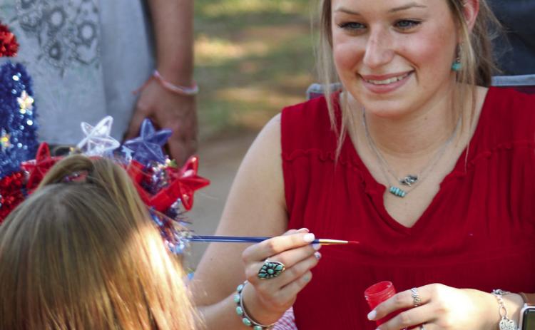 Kady Belle McKee paints children’s faces at the Fourth of July Party in the Park Tuesday, July 4 in Fair Park. The Red River Sun/Elizabeth Tanner