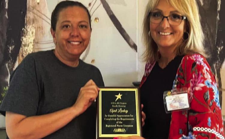 Recently licensed Registered Nurse (RN) April Lindsey accepts recognition from Wellington Care Center (WCC) Administrator Nikki Hathaway. The plaque reads, “LVN to RN Program, proudly honoring April Lindsey: In grateful appreciation for completing the requirements of Registered Nurse Licensure.” Lindsey began her 28-year journey at WCC in 1996 as a certified nurse aid (CNA). Courtesy Photo