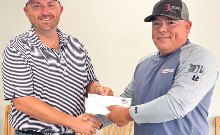 Wellington City Manager Justin Mixon, left, accepts a $10,000 monetary donation in support of the Ellison Park Renovation Project from local AEP-SWECO Lineman Mikey Garza. As citizens of the communities they serve, AEP-SWEPCO strives to donate to nonprofit organizations that improve the quality of life in its communities. On behalf of the Ellison Park Renovation Project Working Group, Mixon expressed his appreciation for the generous gift. City of Wellington