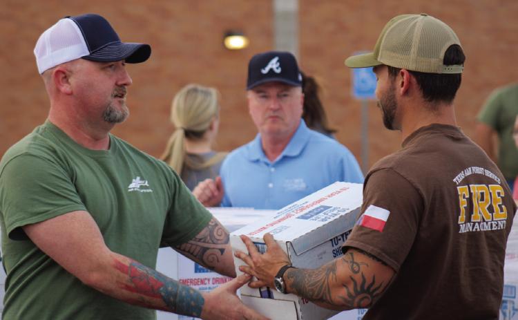 Volunteers unload and distribute water at the community water distribution Monday, Feb. 27 in the Childress High School parking lot. The Red River Sun/Elizabeth Tanner