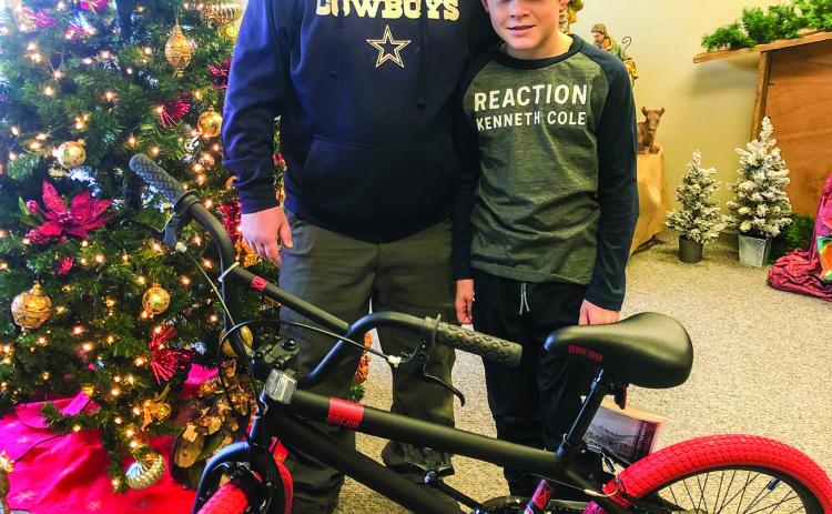 Michael Akemon accompanies his son, Wellington Junior High School sixth-grader Elijah Akemon, to accept the bicycle he won in a drawing during the Lighting of the Square event, presented by Collingsworth County Chamber of Commerce, Saturday, Dec. 3. Courtesy Photos