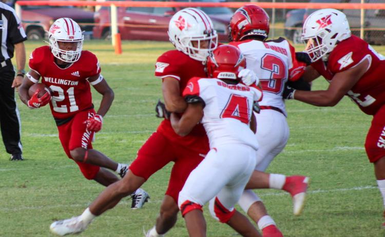 Skyrocket Travon Lewis (21) attempts to run the ball with Anthony Ortiz (15) and Israel Acosta (52) blocking the way. The Red River Sun/Shauna Salinas