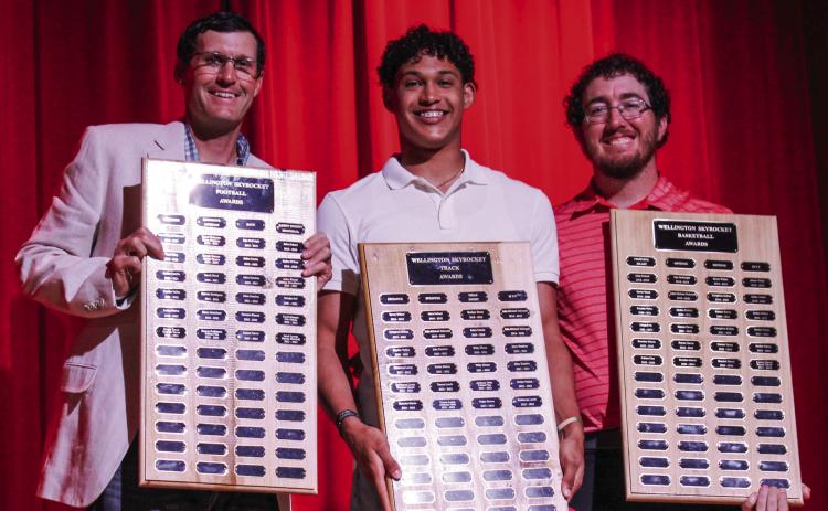 Wellington High School (WHS) senior Brenden Garcia accepts the Football Outstanding Receiver Award, Boys’ Basketball Most Valuable Player (MVP) Award and Boys’ Track Sprinter Award, presented by Athletic Director Greg Proffitt and Coach Quenton Patterson, at WHS’ Academic and All-Sports Banquet at 5:30 p.m. Monday, May 12 at the WHS auditorium. The Red River Sun/Shauna Salinas