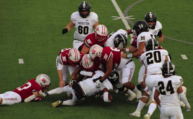 A host of Skyrockets, including Nixon Folk (13), Fabian Pina (65), Caleb Strickland (50), Gatlin Guy (3), Ethan Nevarez (44), Ramon Rodriguez (51) and Jackson Jones, (55) stop Morton’s ball carrier last Thursday, Nov. 16 as the Rockets shutout the Indians in 70-0 final. The Red River Sun/Shauna Salinas