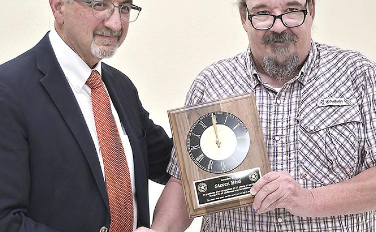 Childress City Attorney Steven Bird (left) receives a plaque from Mayor Cary Preston recognizing his longtime service to the city during a called council meeting Monday night. Bird has served as the city’s attorney for 42 years. The council selected Underwood Law Firm to be the city’s new legal counsel.