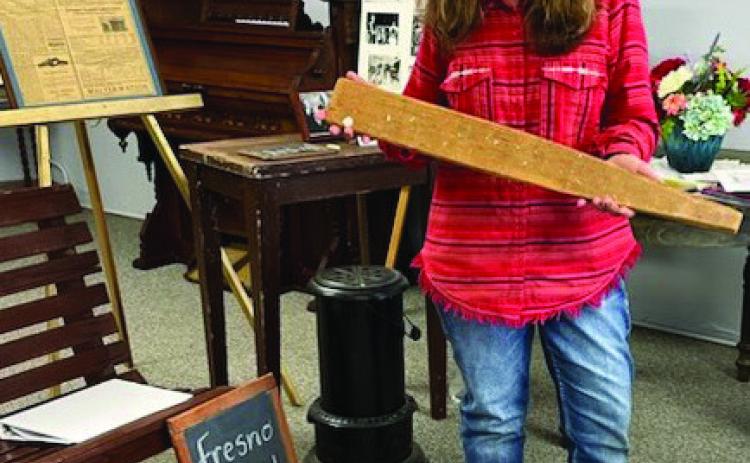 Collingsworth County Museum Director Karen Caldwell demonstrates items, such as a long paddle, in the collection of artifacts from the many county schools. Collingsworth County Retired School Personnel met at the museum for its March meeting. Courtesy Photo