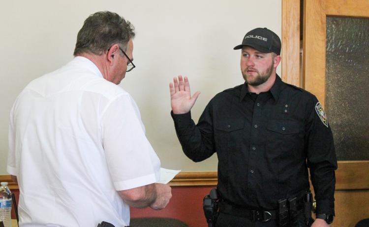 Childress Police Chief Jerrald Johnson swears in new officer Preston Bradley during the Childress City Council meeting Wednesday, March 25 at Childress City Hall. Bradley was joined by his family, including wife Kalin Bradley who pinned on his badge. The Red River Sun/Elizabeth Tanner