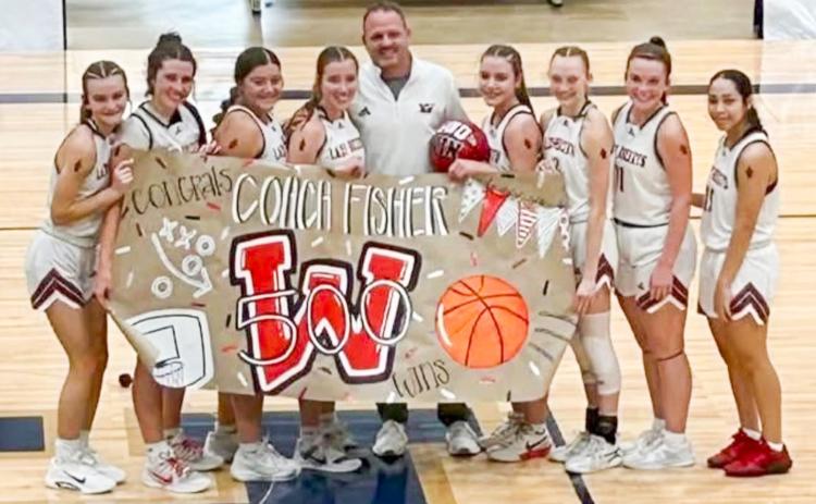 The Lady Rocket basketball team celebrates Coach Shannon Fisher’s 500th career win to highlight the Lady Rockets’ 55-22 semifinal victory on Tuesday afternoon, Dec. 30 at the TexasBank Holiday Classic in Brownwood. From left: Kambrie Fisher, Brynlee Proffitt, Eryn Torrez, Bryn Phillips, Coach Fisher, Gannon Guy, Taytum Kane, Ceighley Killian, Aundrea Garcia. Wellington High School