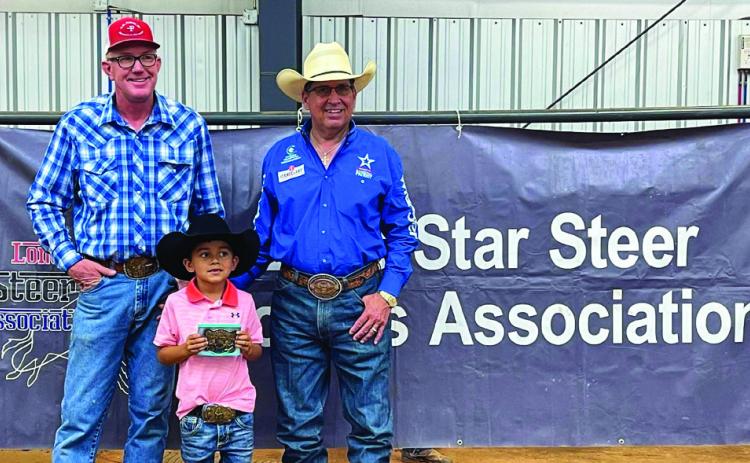 Rod Hartness, right, alongside his son, Rope, accepts a High-Point Buckle from Lone Star Steer Roping Association host Jay Teague. Photos Courtesy of LSSRA