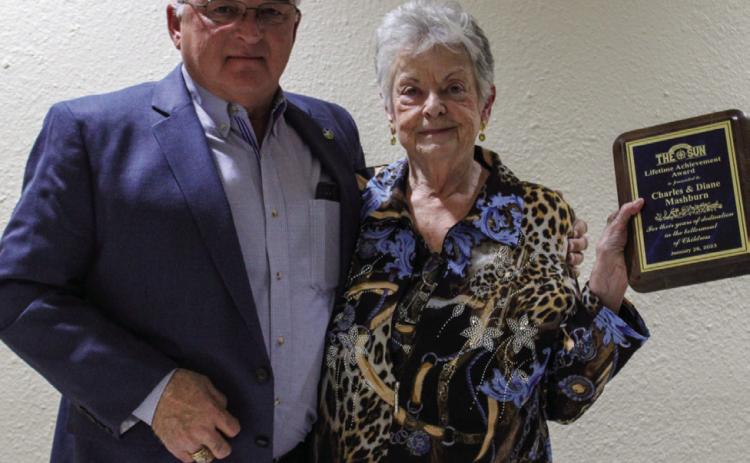Diane Mashburn accepts the Lifetime Achievement Award, given to her and her husband, Charles Mashburn, from Larry Johnson. For additional Childress Chamber of Commerce Banquet awardees, see 7A. The Red River Sun