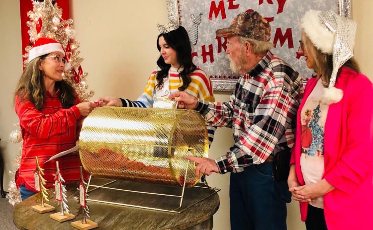 Collingsworth County Chamber of Commerce President Karen Caldwell accepts the first Red Ticket from Miss Wellington Mallory O’Rear. Chamber volunteers Billy Wilkerson and Lisa Manuel assisted with the drawing at 5 p.m. Sunday, Dec. 17 at Collingsworth County Museum. The Red River Sun/Bev Odom