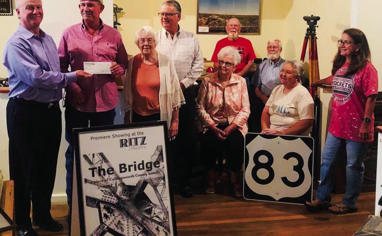 Wellington State Bank (WSB) President Richard Sims presents a $5,000 check to Collingsworth County Museum Board of Directors President Jeff Thomas. WSB is the sole sponsor for “The Bridge” documentary, which is set to be released on YouTube Friday, Nov. 4. From left, Sims, Thomas, Museum Director Doris Stallings, Neal Odom, Nancy Harris, Billy Wilkerson, Oran Sain, Geney Gulley and Assistant Museum Director Karen Caldwell. The Red River Sun/Bev Odom