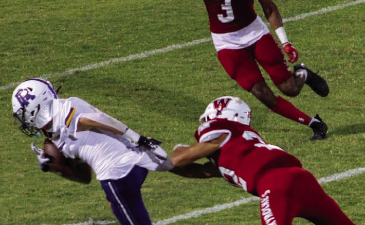 Enrique Jaimes (22) attempts to stop the Wildcat ball carrier while Jordan Nation (3) comes in to bring him down in the homecoming victory against River Road 42-0 last Friday, Sept. 9. The Red River Sun/Shauna Salinas