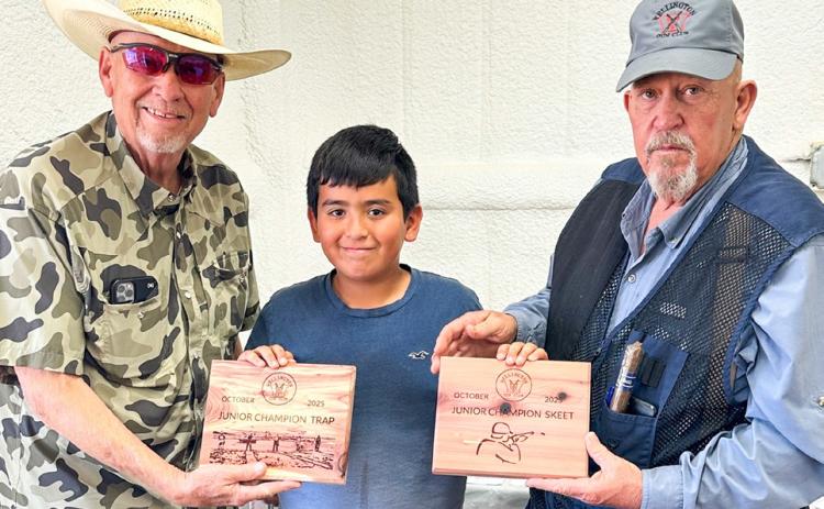 Wellington Junior High School sixth-grader Andrew Skelton, center, accepts the championship award for Wellington Gun Club’s Junior Trap and Junior Skeet competitions at the Saturday, Oct. 18 event. Gun Club Board of Directors Cliff Waller, left, and Kent Riley congratulate Skelton. Wellington Gun Club