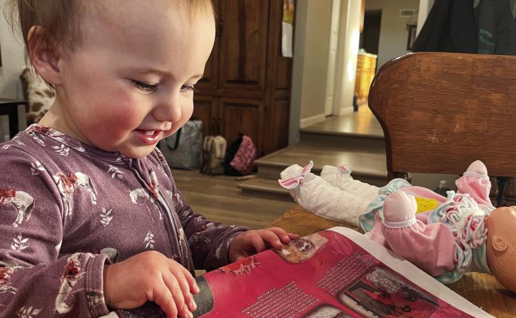 One-year-old Anna Jewel Brown enjoys finding herself with older siblings Trey and Kaylee, plus other children, in the Valentine section of a recent issue of “The Red River Sun.” Brown is the granddaughter of The Red River Sun Associate Editor Bev Odom, of Wellington. Courtesy Photo
