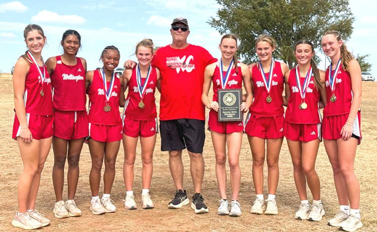 The Wellington Lady Rockets earn the District 2-2A cross country team championship Tuesday, Oct. 13 at the Quanah Country Club. From left: Anna Henard, Priscilla Marentes, Aleah Lewis, Halle Hedrick, Coach Travis Nicks, Taytum Kane, Ava Kate Inman, Claire Kane, and Kaesyn Kane. WELLINGTON HIGH SCHOOL