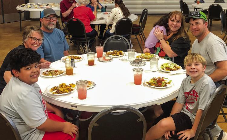 As servings of chocolate, strawberry and lemon sheet cake line the stage of the Bura Handley Community Center, families partake in the Wellington Lions Club Fiesta Pile-On Fundraiser from 5-6:30 p.m. Friday, Nov. 7. The Lions appreciate the overwhelming support of the community. Clockwise, from left: Layton Wynn, Stacey and Michael Breedlove, Charlotte, Cari-Anna, Matt and Stratton Wynn. In the background are Ray and Phyllis Floyd, Carolyn Keller and D’Lyn Faulks. The Red River Sun/Bev Odom