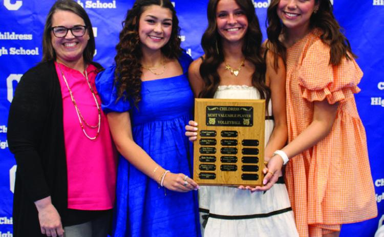 Head volleyball coach Misty Roark, left, awards Volleyball Co-Offensive MVPs Journey Prince, right, and Kaydence Simpkins, second from left, and Volleyball Defensive Most Valuable Player (MVP) Chloe Churchill, second from right.