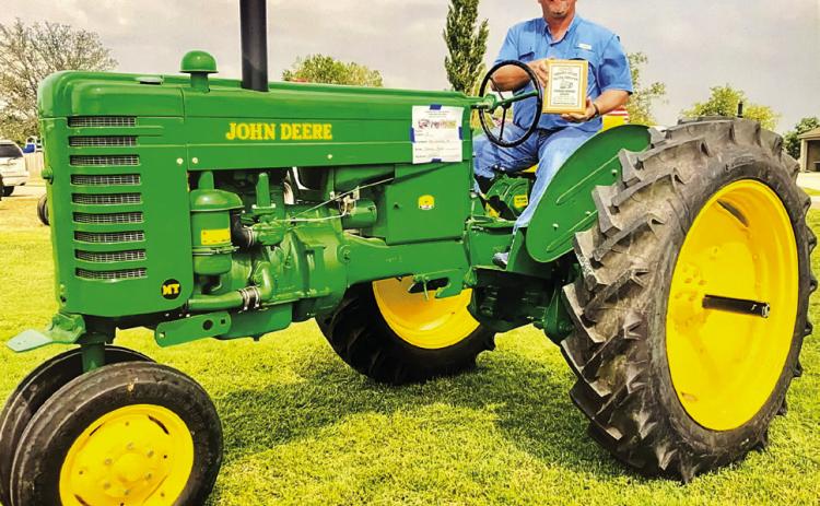 Kenneth Ellis’ classic John Deere tractor, shown by Chance Taylor, brings home the Founders Memorial Award at the recent 21st Annual Panhandle Antique Tractor Association Show and Raffle at High Plains Children’s Home and Family Services in Amarillo. Courtesy Photo