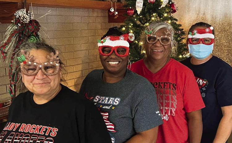 Getting ready for the holiday season, certified nurse aids at Wellington Care Center line up in front of the fireplace. Courtesy Photo