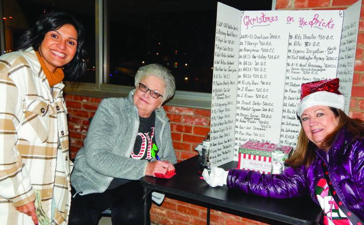Collingsworth Chamber of Commerce volunteers Nancy Harris and Margret Wood sell Christmas on the Bricks Red Tickets, for a $10 donation per ticket, to Becky Reyes, left, during the Lighting of the Square event last Saturday evening, Dec. 3. The famous courthouse star even appeared around dusk as Santa and Mrs. Claus gave the signal for the lighting. The Red Ticket drawing will take place at 5 p.m. Saturday, Dec. 17 at Collingsworth County Museum. The Red River Sun/Bev Odom