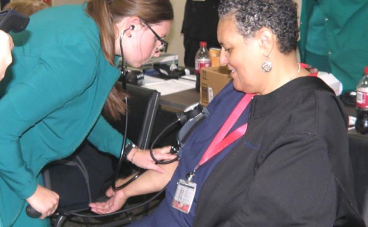 Sylvia Douglas of Clarendon College does a blood pressure reading for Kady Belle McKee at the CRMC/ Childress County Extension Service Health Fair. A blood sugar level test also was administered, with McKee given a log to maintain before seeing her personal physician. INTREPID PHOTO / GRACE HOLMAN