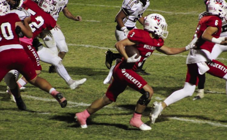 Wellington’s offensive line, including Major Brown (6), Hunter Hedrick (52) and RJ Granadoz (60), blocks a path for Gunner Guy (3) during the Rocket’s 49-6 win over Quanah Friday, Oct. 18 at Powell Field in Wellington. The Red River Sun/Shauna Salinas