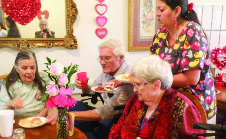 Cottage Village Assisted Living Facility residents celebrate Valentine’s Day with a mid-afternoon party. Hosted by staff, party assistance was provided by Lila Hoobler, Anne Fromm and Joe Robinson, shown with Linda Hunter, left, and Frances Weatherbee, right. Serving is Cottage Village cook Esther Martinez.