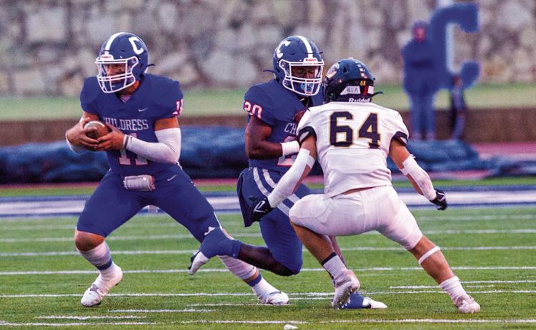 Childress’ Scout Smith (11) moves the ball while Dareon Mathis blocks out Canadian’s D’wayne Moran during the district opener Friday, night Oct. 7 at Fair Park Stadium. The Red River Sun/Nicole Dill