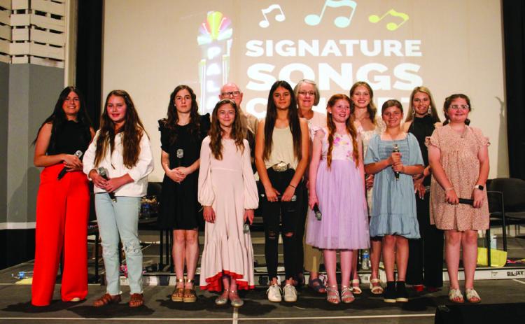 Monson Music Studio vocal students perform signature songs, including “What a Wonderful World” by Louis Armstrong, “I Hope You Dance” by Leanne Womack, “Wide Open Spaces” by the Dixie Chicks and more, at the Palace Theater Sunday, May 7. From left: Lacy Teichroeb, Ava Barlow, Saylee Ochoa, Selah Smith, Gerald Monson, Heather Peters, Shirley Weir, Liesel Schaefer, Summer Neufeld, Grace Peters, Maggie Tillman and Harper Hall. The Red River Sun/Elizabeth Tanner