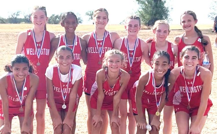 The Wellington Junior High School Lady Firecrackers, including front, Kesley Hamner, Mariah Medina, Calleigh Henard, Aryen Garcia, Quinn Roberson, and back, Kenlea Martin, Jadah Casas, Evey Henard, Taytum Martin, Veva Finnegan, and Berkley Ward, earned the Junior High District 2-2A cross country title on Tuesday afternoon, Oct. 13, at Quanah Country Club. WELLINGTON JUNIOR HIGH SCHOOL