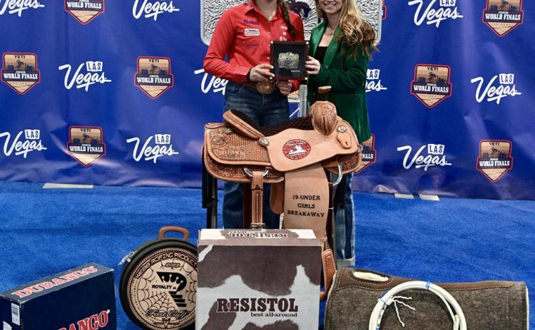 Tell’s Colee Cox, 16, takes home the 19-and-under girls breakaway roping championship at the Junior World Finals Saturday, Dec. 9 in Las Vegas, Nev. She is congratulated by Junior World Finals Assistant General Manager Brilynn Bentley. Courtesy Photos