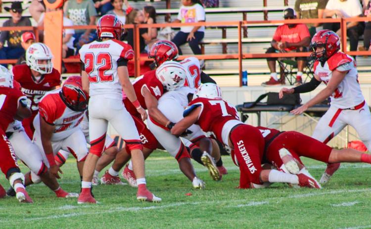 Skyrockets Ethan Nevarez (44) and Dalton Holland (73) jump on the tackle, while Ramon Rodriguez (51), Jackson Jones (55) and Gatlin Guy (3) attempt to hold off the Bombers for a successful tackle Friday night, Aug. 25. The Skyrockets shutout the Bombers 30-0 for their first home game of the season on Powell Field. The Red River Sun/Shauna Salinas