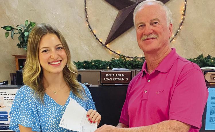 Wellington High School Class of 2024 Valedictorian Summer Neufeld accepts a $2,000 scholarship award Thursday, Aug. 8 from Wellington State Bank (WSB) President Richard Sims. An employee at WSB for the past two summers, Neufeld has enrolled in Texas Tech University in Lubbock to study finance. Her minor is interior design. Her goal is to pursue a career in the banking field after college. Courtesy Photo