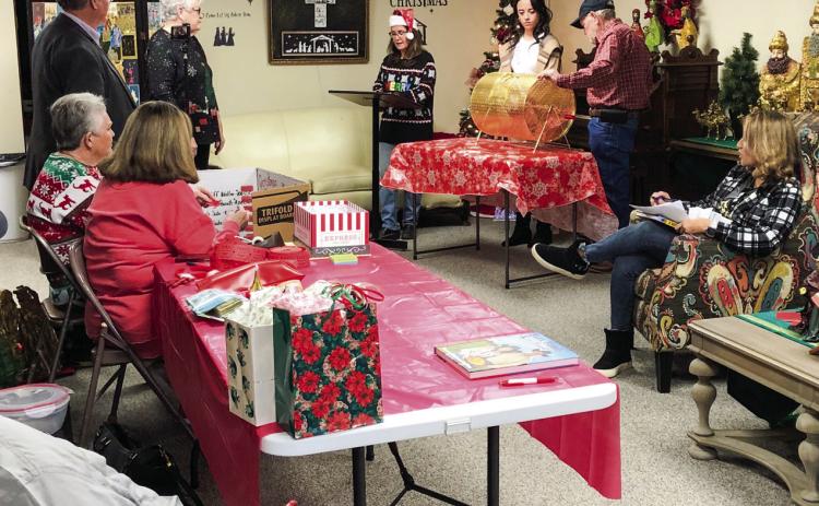 Citizens gather in the Ellis Art Center of the Collingsworth County Museum, amongst the Nativity and Wise Men exhibit, for the Christmas on the Bricks RED TICKET drawing at 5 p.m. Saturday, Dec. 17. Geney Gulley, left, Margret Wood, Neal Odom and Nancy Harris assist Karen Caldwell, Miss Wellington Summer Owens, Billy Wilkerson and Cecilia Orozco with the drawing and listen intently for names of the winners. The Red River Sun/Bev Odom