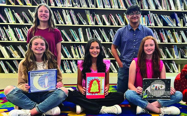 Wellington Junior High School published authors and illustrators, including Addalyn English and Elli Ouellette, left, Ingrid Granadoz and Bailey Page and Christopher Reyes, display their books during the Meet the Author Night, hosted by Collingsworth Public Library. Courtesy Photos