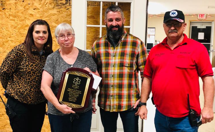 Wellington Emergency Medical Service commends Pat Needham for 35 years of dedicated and loyal service to the community as a first responder. “Your hard work is unmatched,” reads her plaque. From left, Samantha Blacksher, Needham, Noah Downing, Farris Nation. The Red River Sun/Bev Odom