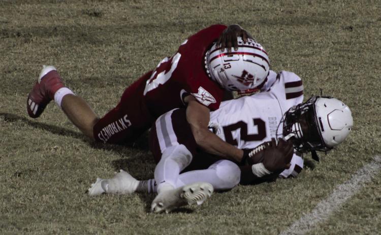 Skyrocket Nixon Folk (13) tackles Clarendon’s quarterback, Lyric Smith (2), in the district championship game last Friday, as Wellington fell 36-20, finishing as the No. 2 seed in the district. The Red River Sun/Shauna Salinas